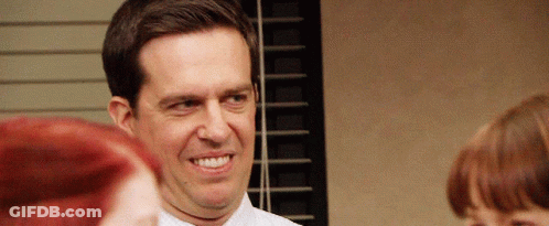 A Man In A White Shirt And Tie Is Smiling While Standing In Front Of A Window GIF