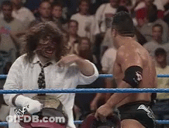 A Man In A White Shirt And Tie Is Standing In A Wrestling Ring GIF