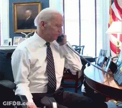 A Man In A White Shirt And Tie Is Talking On A Cell Phone GIF