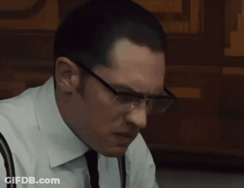 A Man In A White Shirt And Tie Sits At A Table With A Plate Of Food GIF