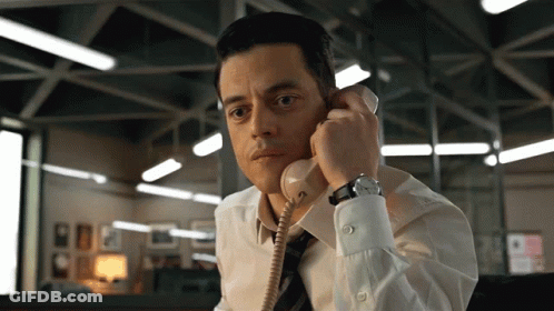 A Man In A White Shirt And Tie Talking On A Telephone GIF