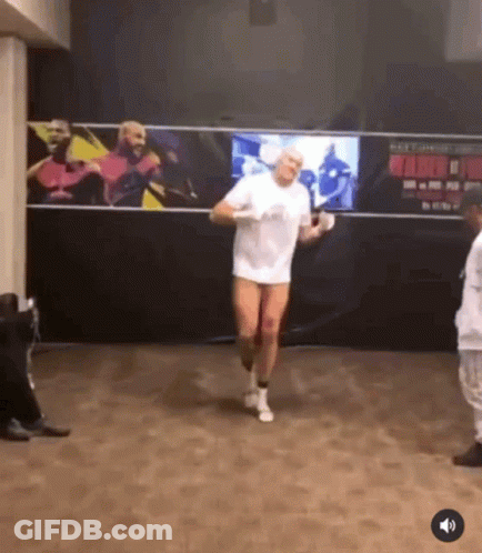 A Man In A White Shirt And White Socks Is Jumping Rope In A Gym GIF