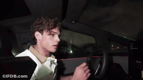 A Man In A White Shirt Driving A Car GIF