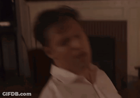 A Man In A White Shirt Holds A Microphone In His Hand GIF