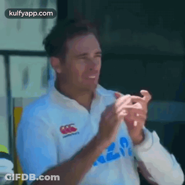 A Man In A White Shirt Is Clapping His Hands GIF