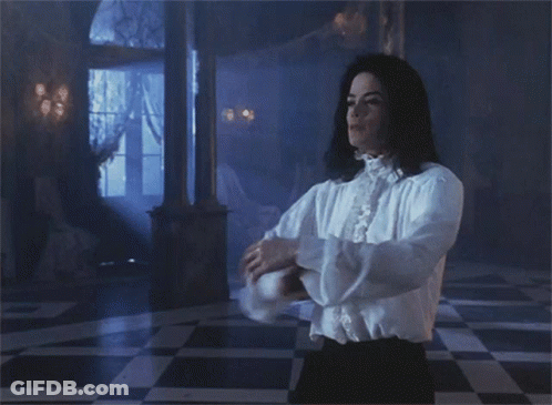 A Man In A White Shirt Is Dancing In A Room GIF