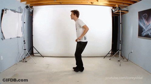 A Man In A White Shirt Is Dancing In A Room With Youtube.com/coreyvidal Written In The Corner GIF