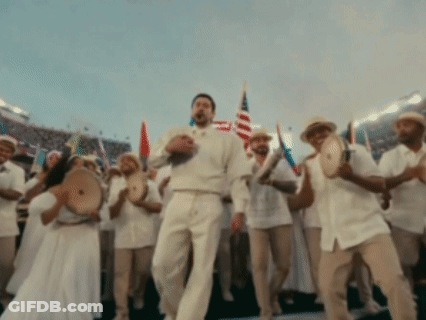 A Man In A White Shirt Is Dancing In Front Of A Crowd GIF