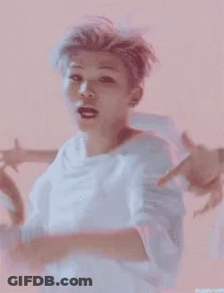 A Man In A White Shirt Is Dancing In Front Of A Group Of Men GIF