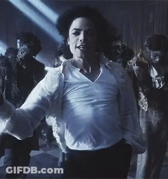 A Man In A White Shirt Is Dancing In Front Of A Group Of People In Costumes GIF