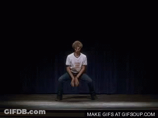 A Man In A White Shirt Is Dancing On A Stage GIF