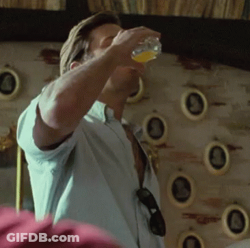 A Man In A White Shirt Is Drinking From A Glass GIF