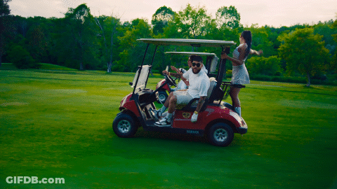 A Man In A White Shirt Is Driving A Red Yamaha Golf Cart GIF