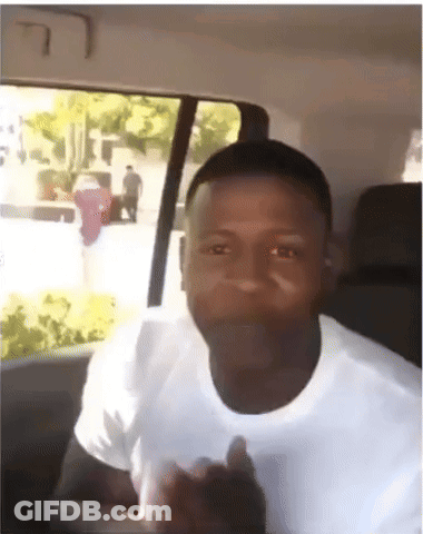 A Man In A White Shirt Is Giving A Thumbs Up In A Car GIF