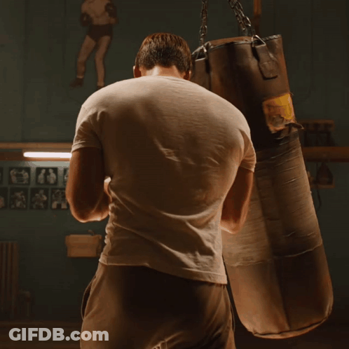 Man In White Shirt Hitting Punching Bag GIF