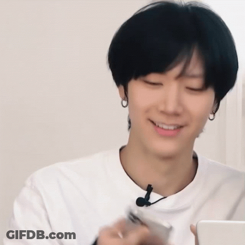 A Man In A White Shirt Is Holding A Cell Phone GIF