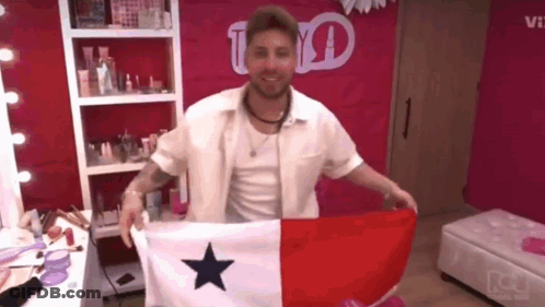 A Man In A White Shirt Is Holding A Flag With A Blue Star On It GIF