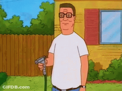 A Man In A White Shirt Is Holding A Hose In His Hand In Front Of A House . GIF