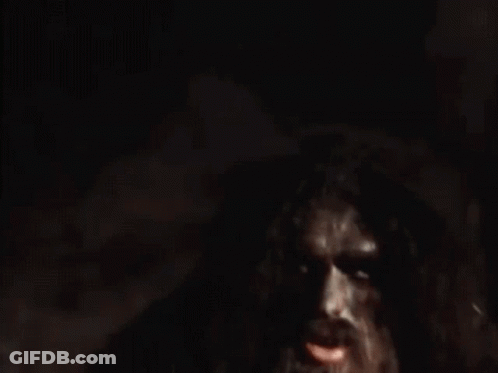 A Man In A White Shirt Is Holding A Large Piece Of Wood . GIF