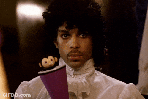 A Man In A White Shirt Is Holding A Purple Object GIF