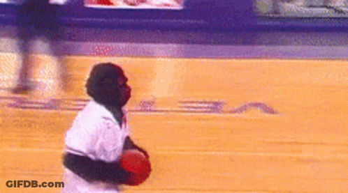 A Man In A White Shirt Is Holding A Red Ball On A Basketball Court With The Letter S On It GIF