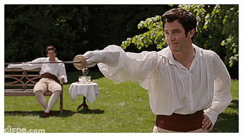 A Man In A White Shirt Is Holding A Sword In Front Of Another Man Sitting On A Bench GIF
