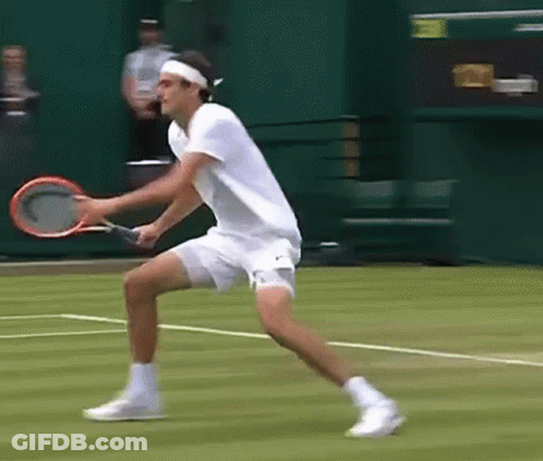 A Man In A White Shirt Is Holding A Tennis Racquet On A Court GIF