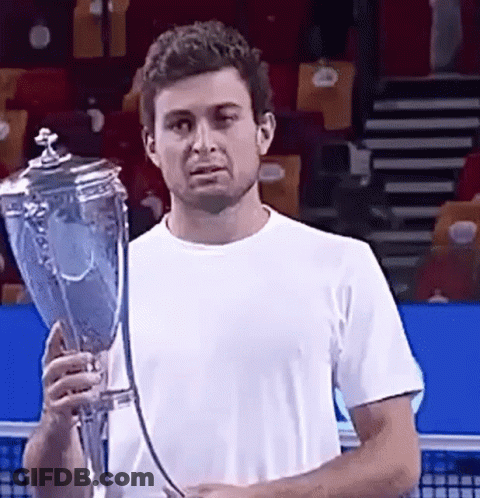 A Man In A White Shirt Is Holding A Trophy GIF