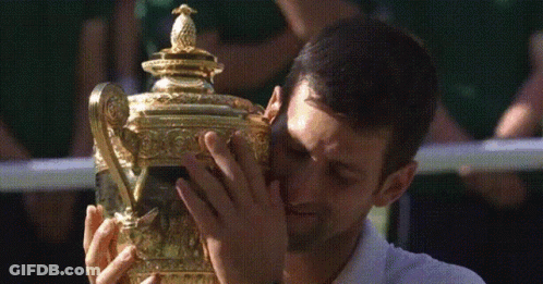 A Man In A White Shirt Is Holding A Trophy GIF