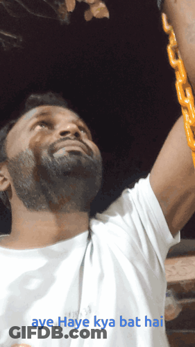 A Man In A White Shirt Is Holding A Yellow Chain And The Caption Aye Haye Kya Bat Hai GIF