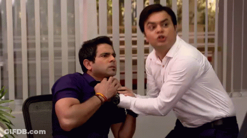 A Man In A White Shirt Is Holding Another Man In A Purple Shirt GIF