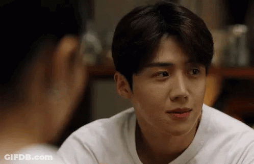 A Man In A White Shirt Is Looking At A Woman In A Mirror . GIF