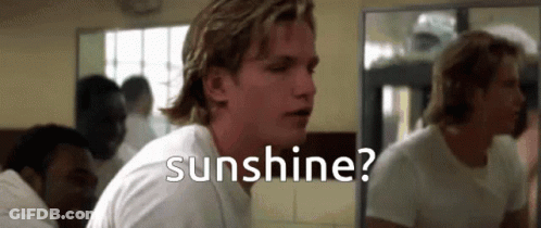 A Man In A White Shirt Is Looking At Himself In A Mirror And The Word Sunshine Is Above Him GIF