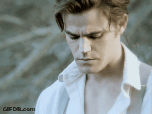 A Man In A White Shirt Is Looking Down With His Eyes Closed GIF
