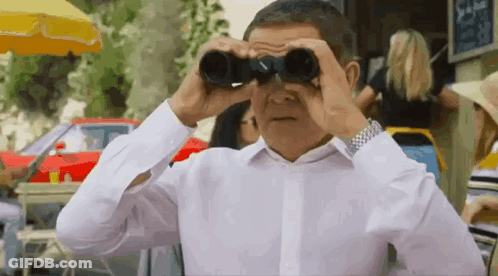 A Man In A White Shirt Is Looking Through Binoculars In A Crowded Street . GIF
