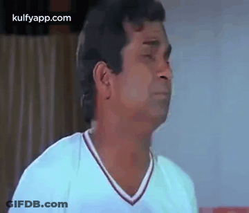 A Man In A White Shirt Is Making A Face . GIF