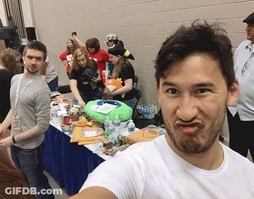 A Man In A White Shirt Is Making A Funny Face In Front Of A Crowd GIF