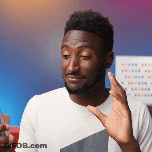 A Man In A White Shirt Is Making A Funny Face While Holding A Cell Phone GIF
