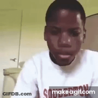 A Man In A White Shirt Is Making A Funny Face While Looking At The Camera . GIF