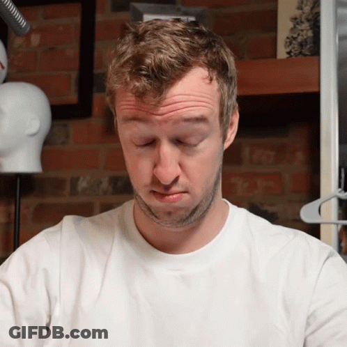 A Man In A White Shirt Is Making A Funny Face With His Eyes Closed GIF