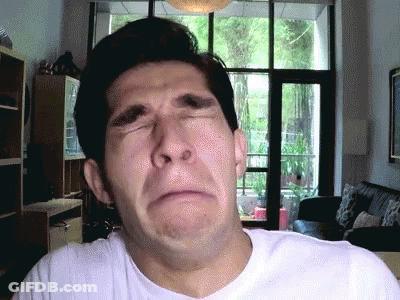 A Man In A White Shirt Is Making A Funny Face With His Eyes Closed GIF