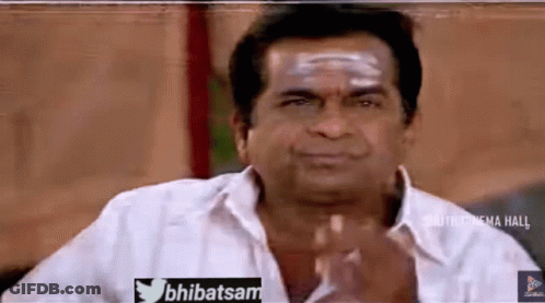 A Man In A White Shirt Is Making A Funny Face With His Hands . GIF