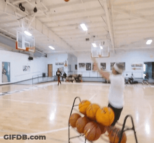 A Man In A White Shirt Is Playing Basketball On A Court GIF
