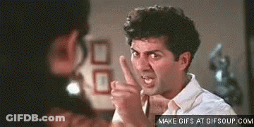 A Man In A White Shirt Is Pointing At Another Man With His Finger . GIF