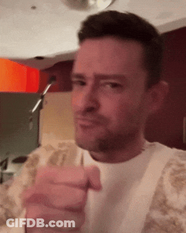 A Man In A White Shirt Is Pointing At The Camera With His Finger GIF