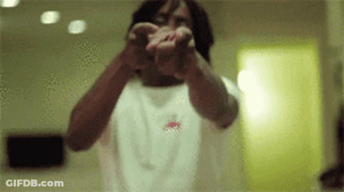 A Man In A White Shirt Is Pointing At The Camera With His Hands GIF