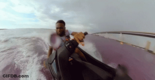 A Man In A White Shirt Is Riding A Jet Ski GIF