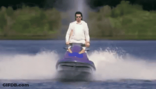 A Man In A White Shirt Is Riding A Jet Ski In The Water GIF