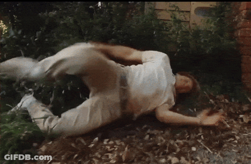 A Man In A White Shirt Is Rolling On The Ground GIF