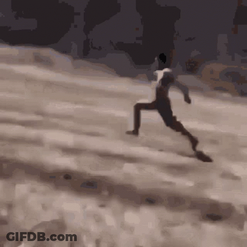 A Man In A White Shirt Is Running On A Sandy Hill GIF
